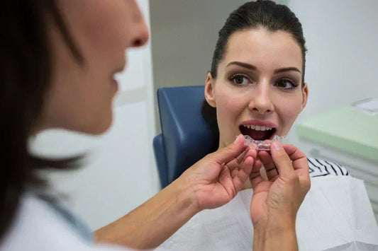 An orthodontist applying clear aligners to a patient